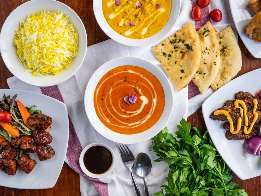 A table of Indian curries, rice, naan and accompaniments